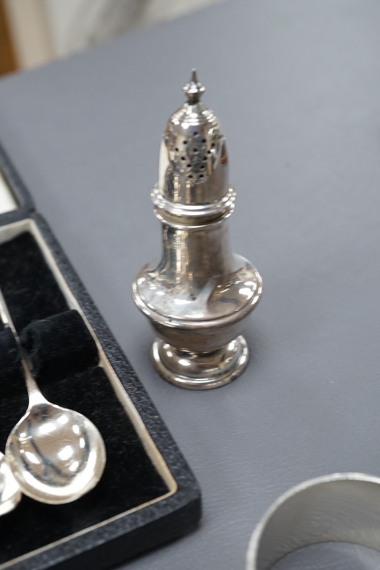 Four assorted silver napkin rings, two cased sets of six silver spoons, four silver condiments including a pair, a small group of sundry flatware, a silver wine label and a plated napkin ring.